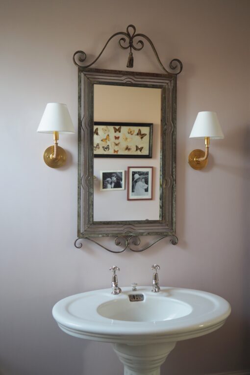 Wall sconce light in pink bathroom